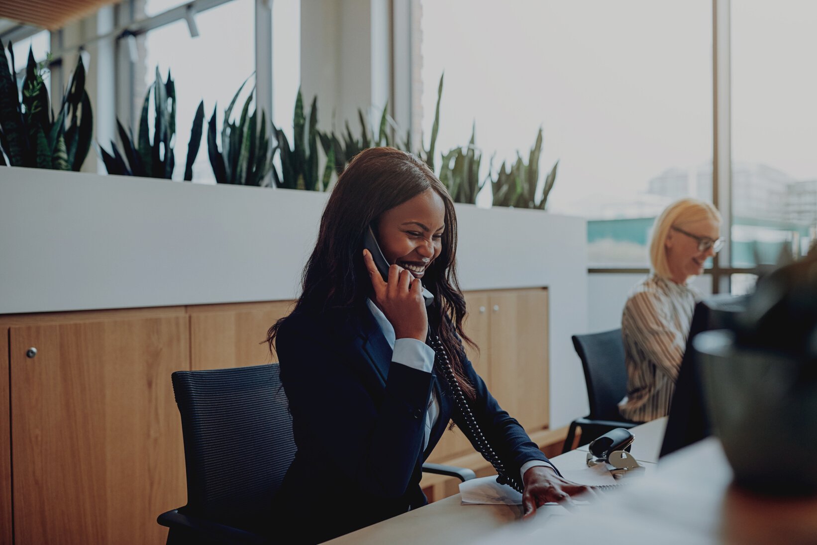 Laughing African American businesswoman talking on an office phone